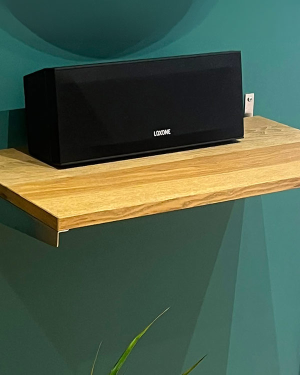 Espai del showroom amb televisor, equip d’àudio i taula de reunió